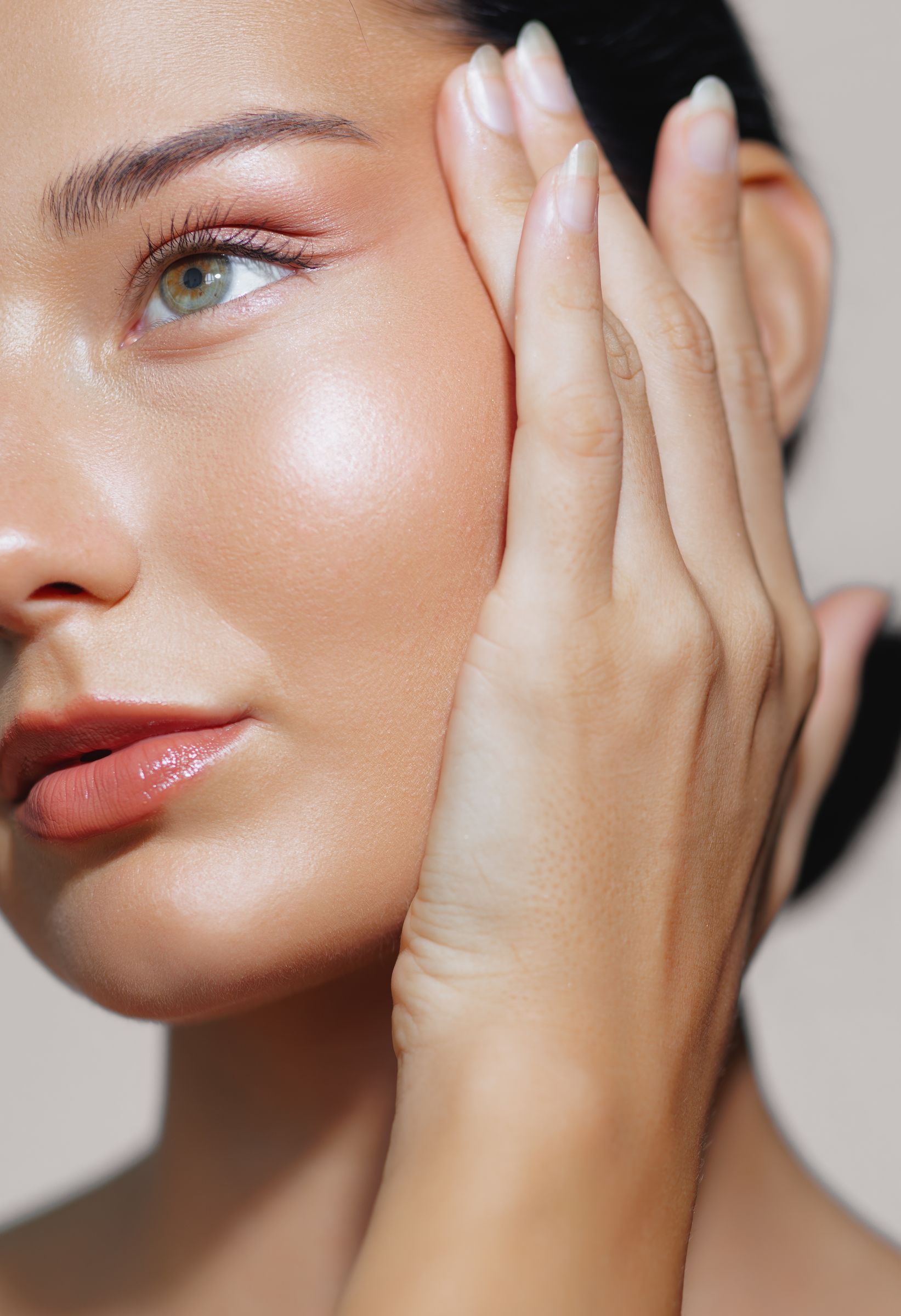A close up of a woman 's face with her hand on it.