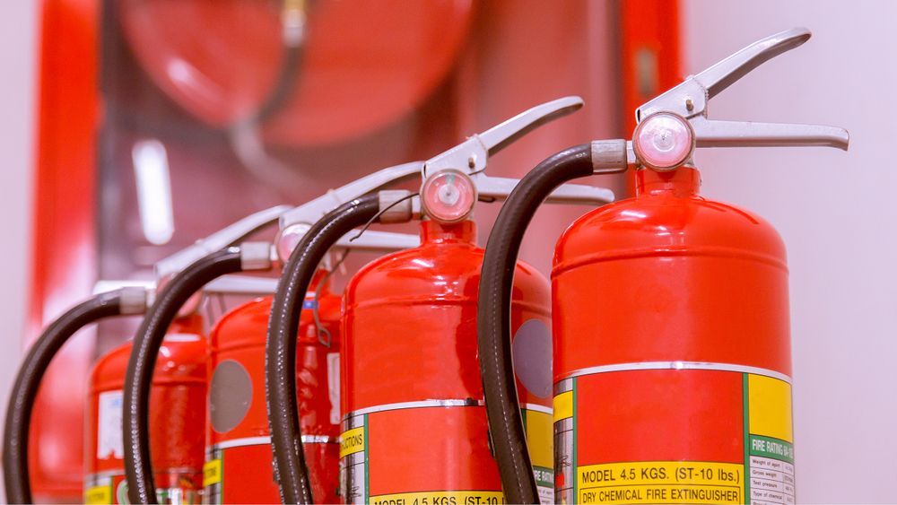 Row of Red Fire Extinguishers with Hoses and Pressure Gauges — Pasiv Fire in Illawarra, NSW