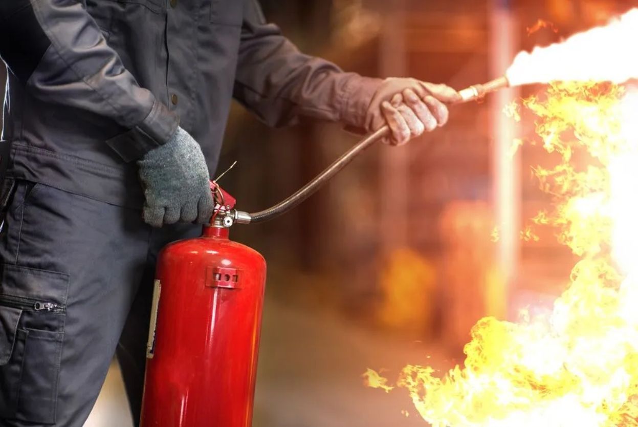 Fire Safety In Wollongong Firefighter Using Extinguisher On Blazing Fire