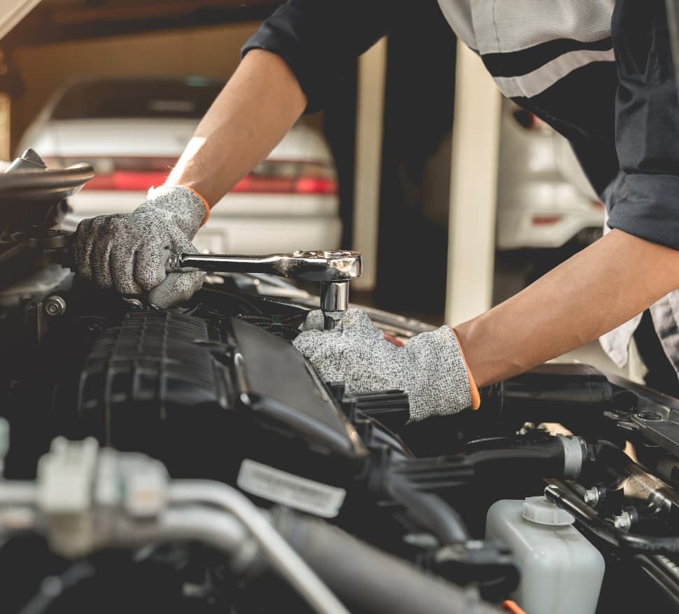 A Man Is Working On The Engine Of A Car — Ultra Mechanics In Warana, QLD