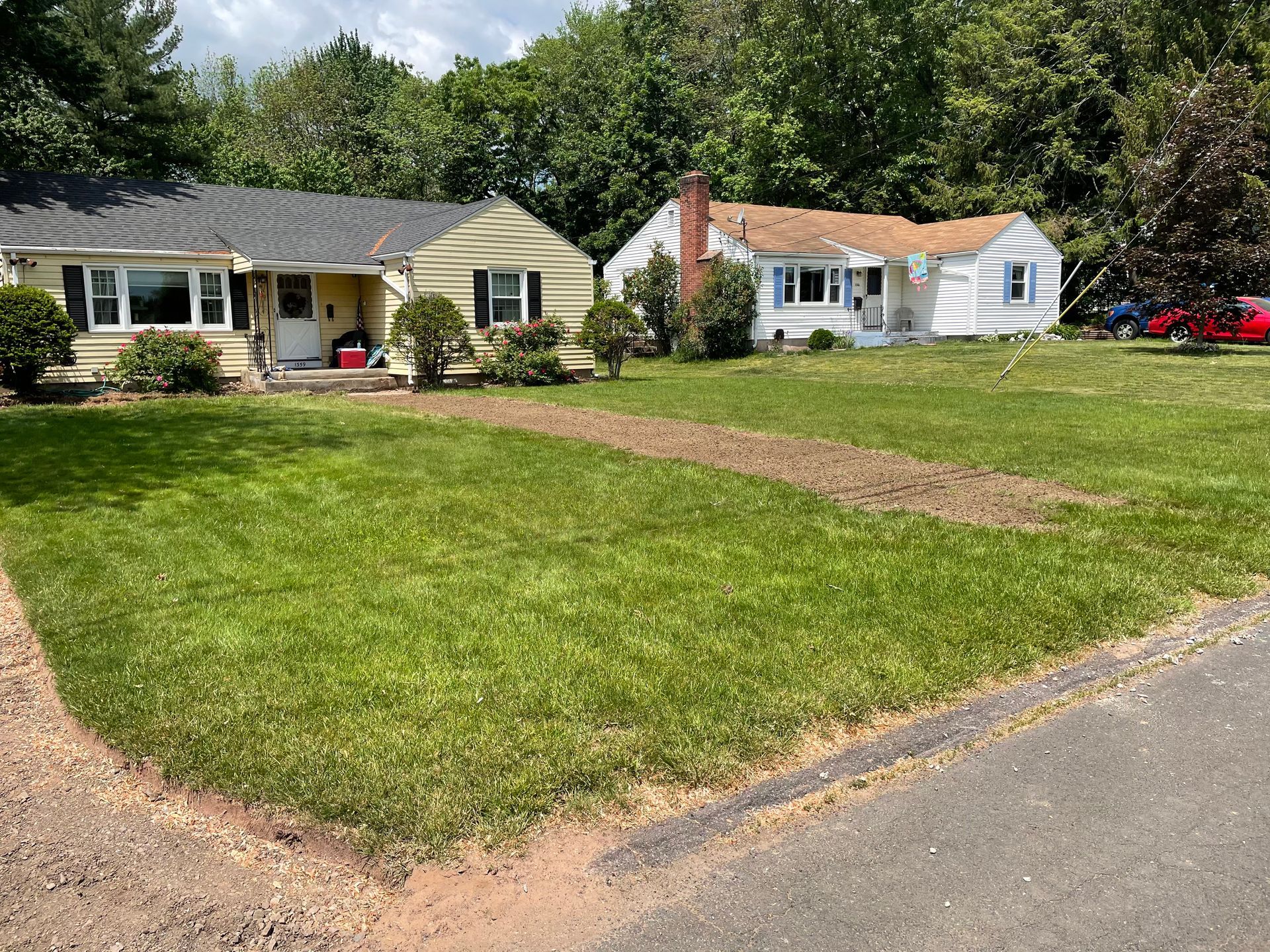 Three houses with lawns; two are yellow and one is white.