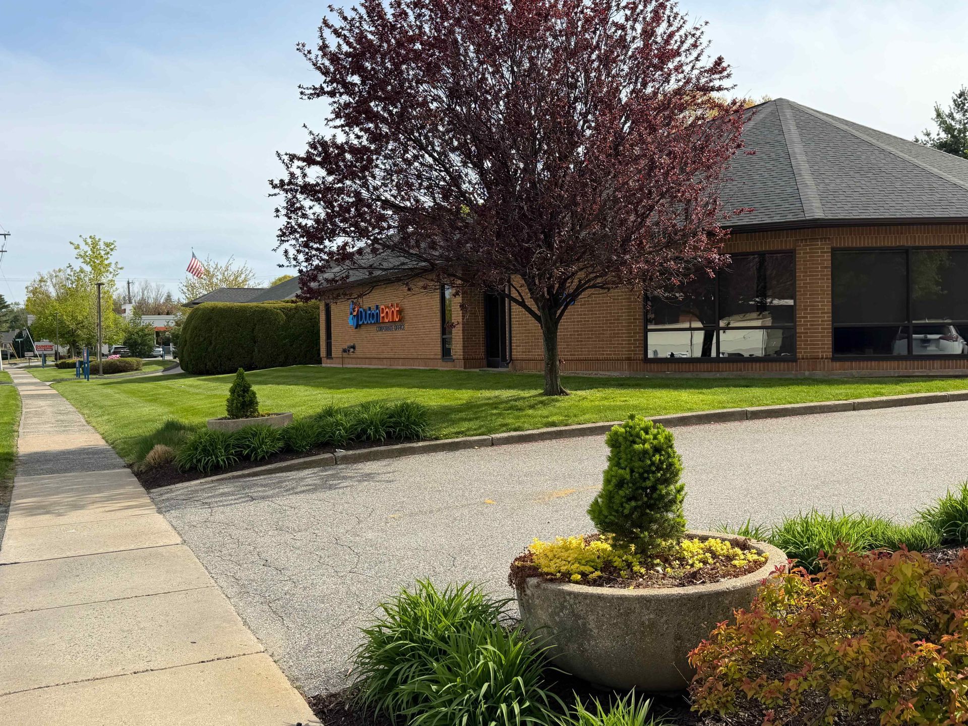 Landscaped office building with gravel drive, sidewalk, and flowering trees