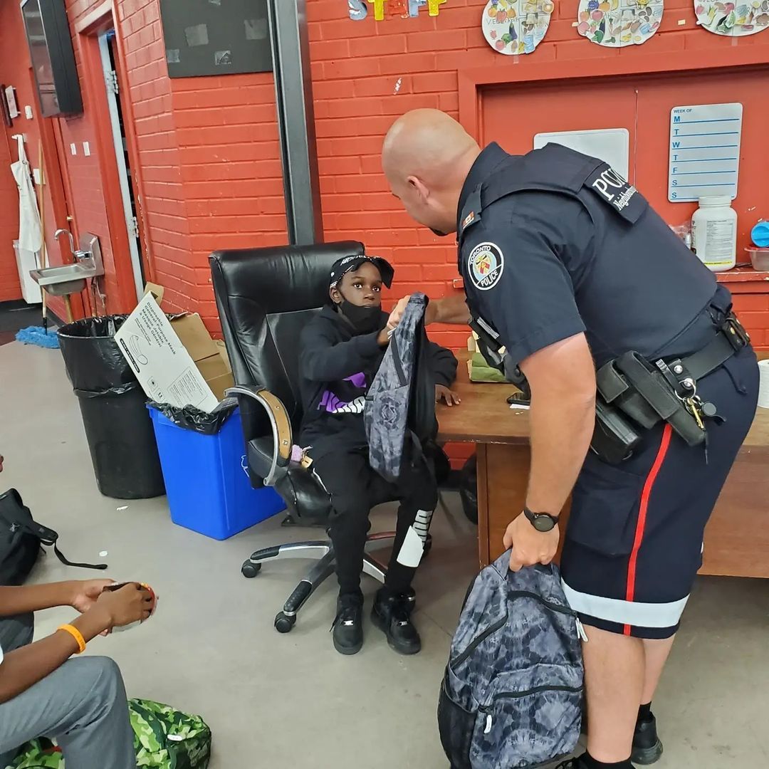 NCO giving youths school bags