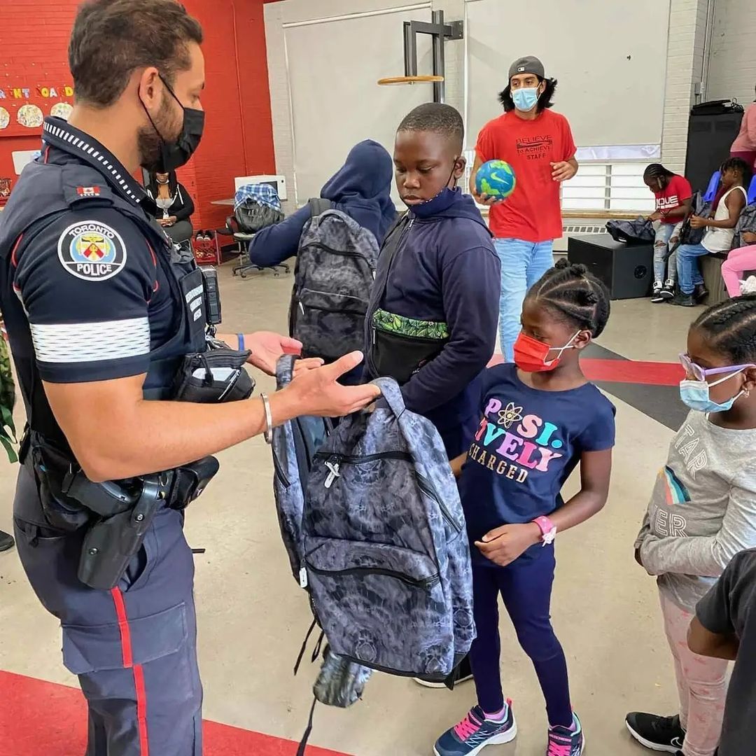 NCO giving youths school bags