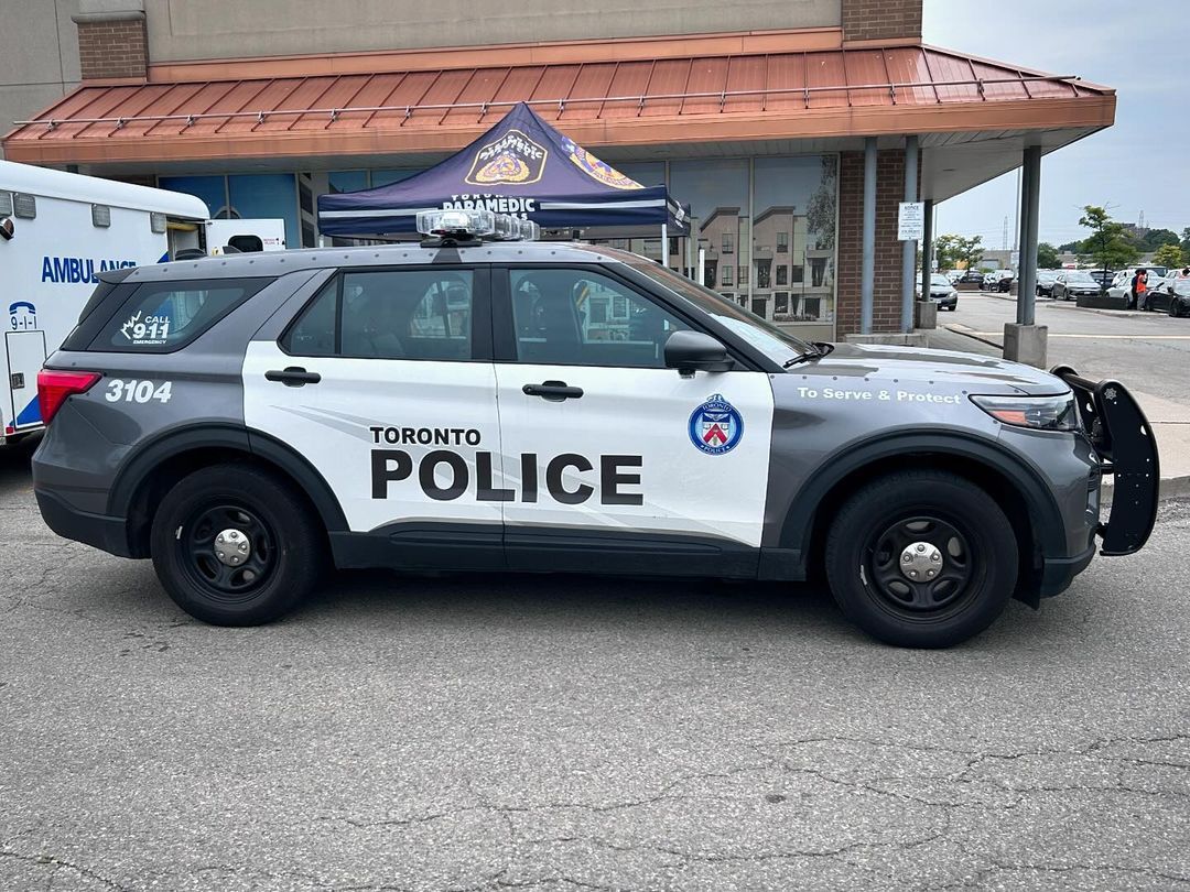 A toronto police car is parked in front of a building.