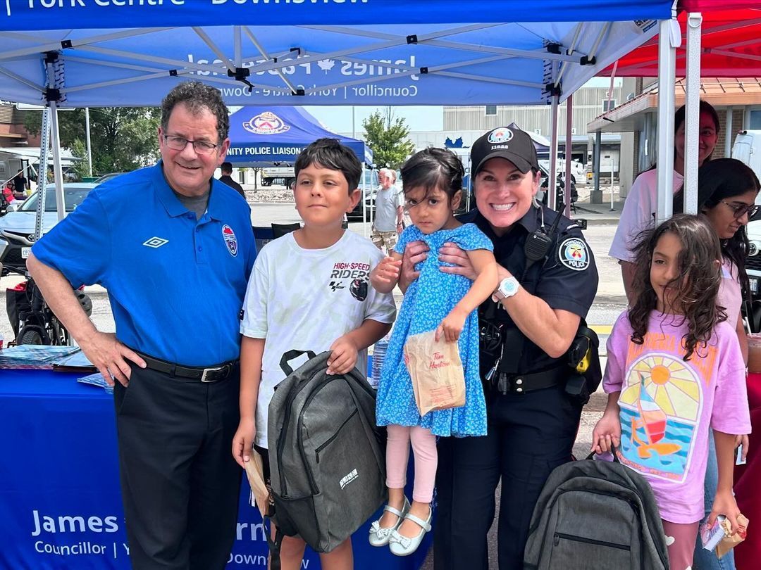 A group of people posing for a picture in front of a tent.