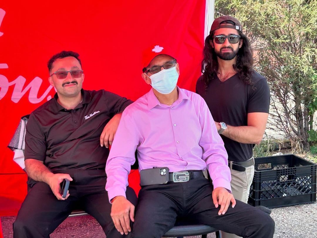 Three men wearing face masks are posing for a picture.