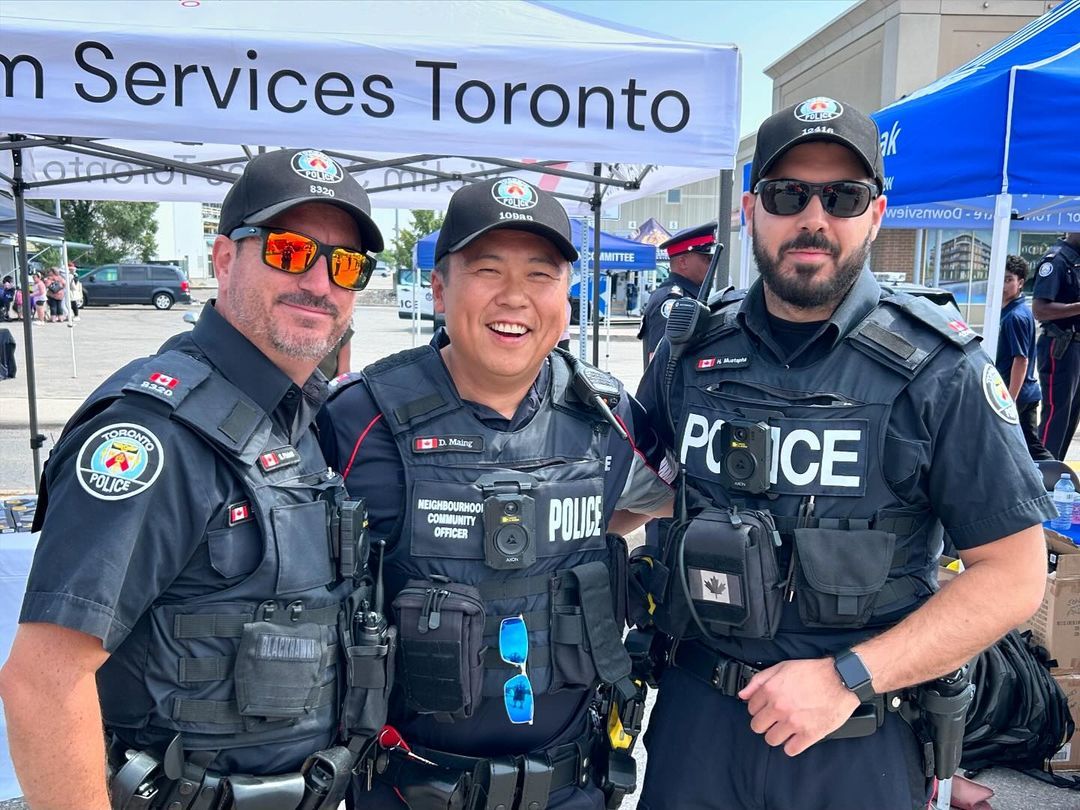 A group of police officers are posing for a picture in front of a tent.