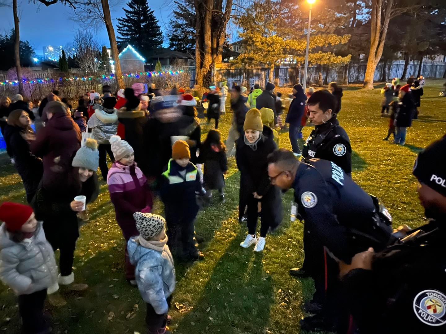 a group of people are gathered in a park with police officers