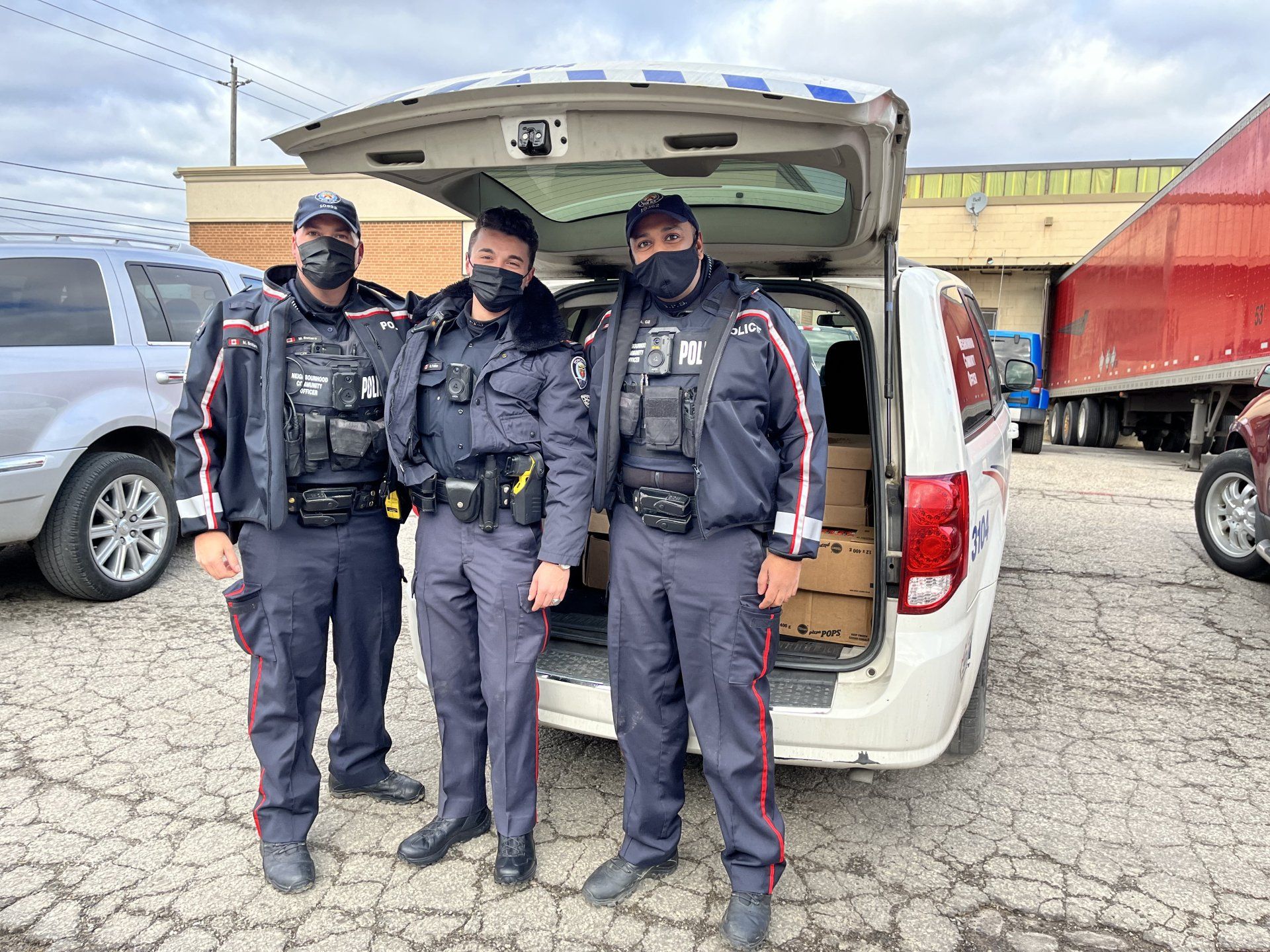 NCOs standing by van full of food