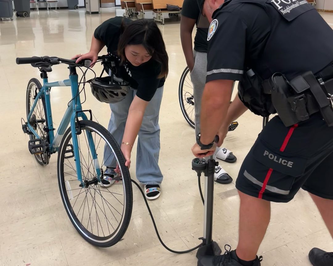 A police officer is pumping a bicycle tire