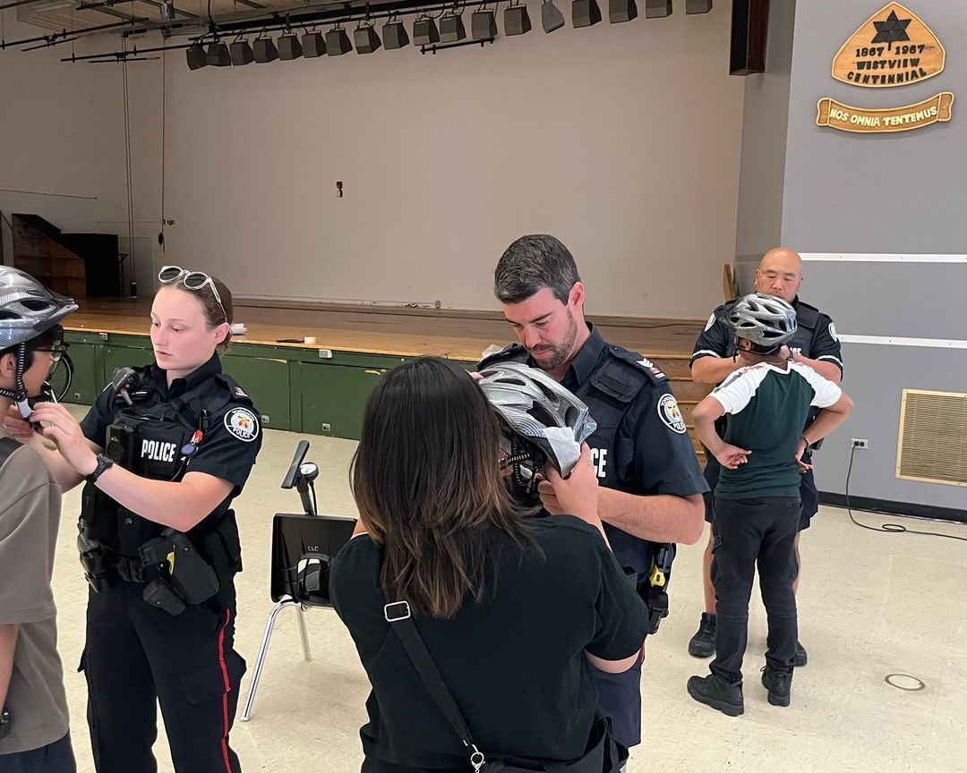 A group of police officers are helping a woman put on a helmet.