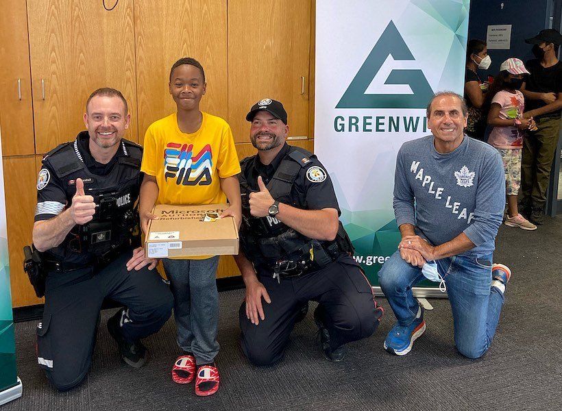 Officers and Kevin Green taking a picture with a youth