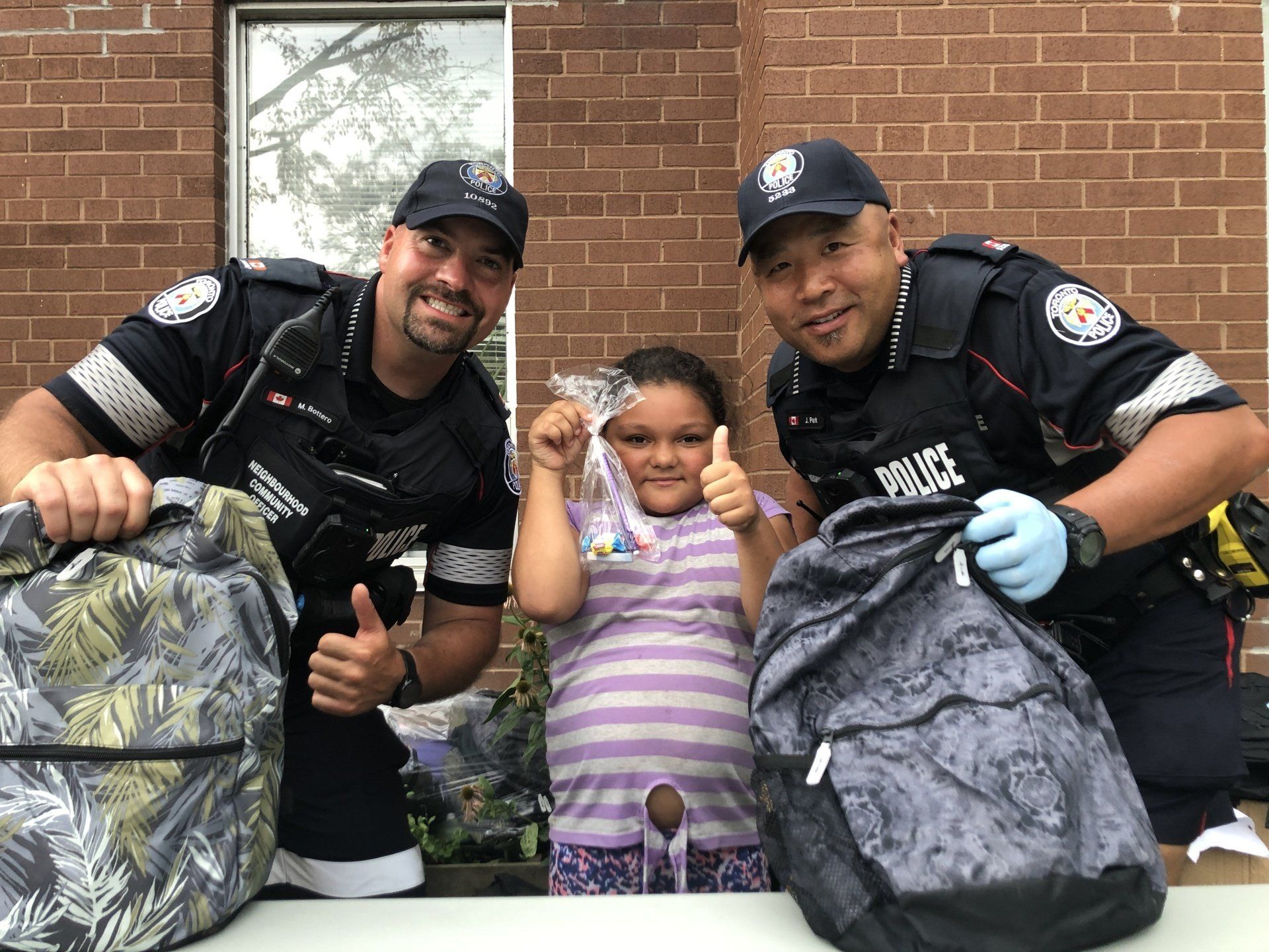 Two officers posing with child