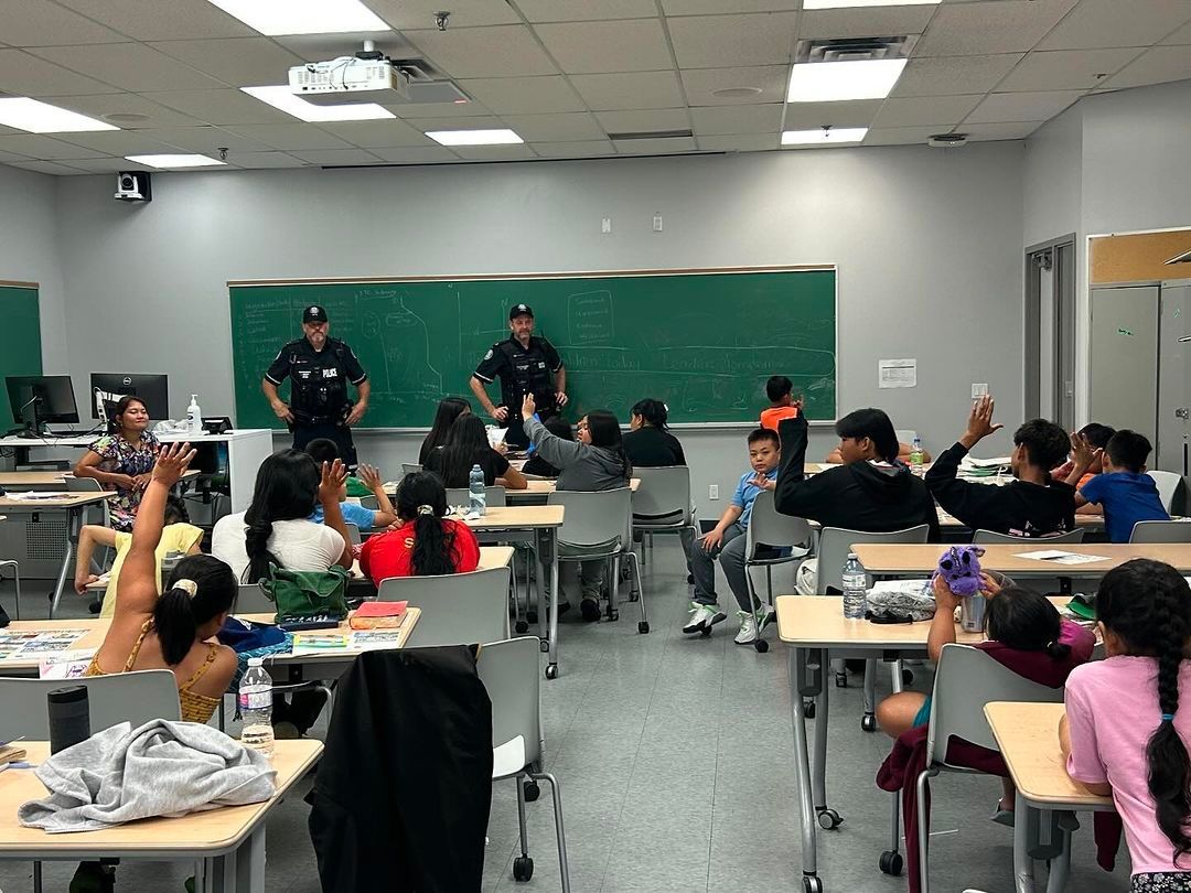 A group of children are sitting at desks in a classroom.