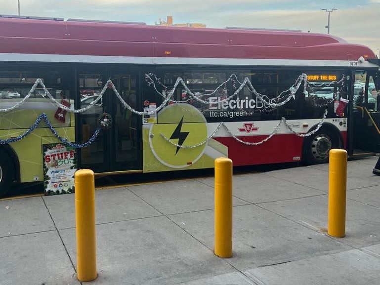 a red and yellow electric bus is decorated for christmas