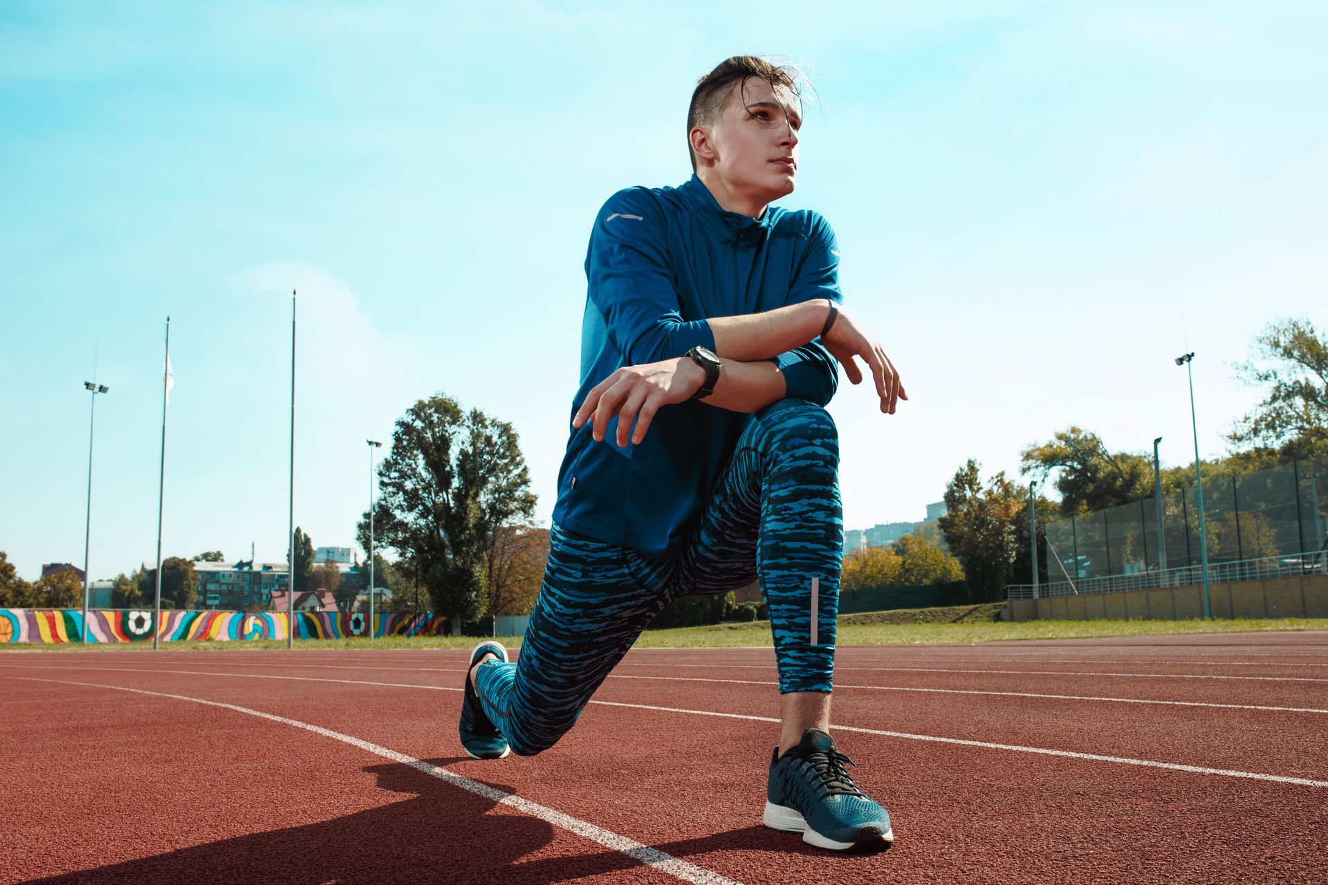 a man is stretching his legs on a track .