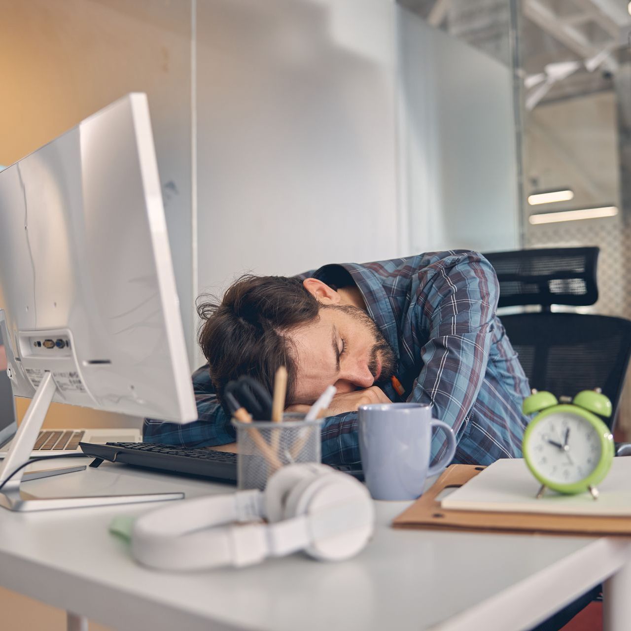 a man is sleeping on a desk in front of a computer