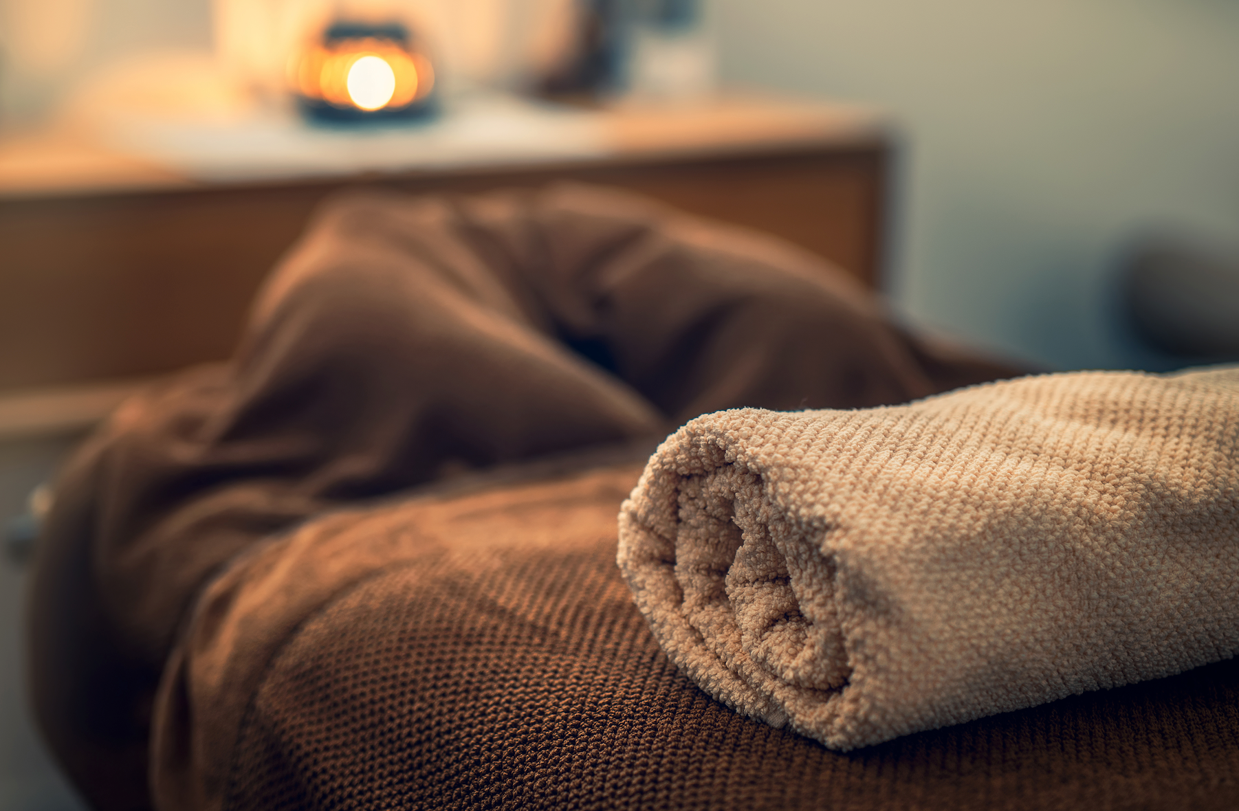 A person is laying on a bed with a towel on it.