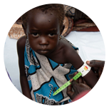 Uma menina está sendo medida por uma pessoa em um círculo.