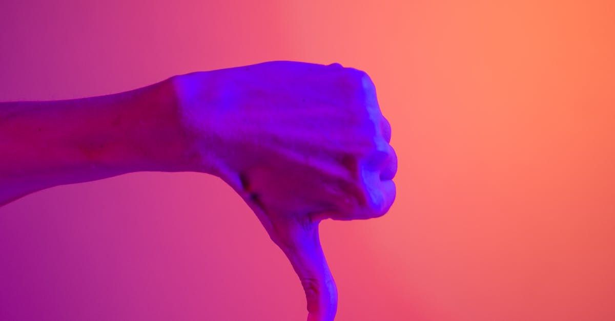 A close up of a person 's hand giving a thumbs down sign.