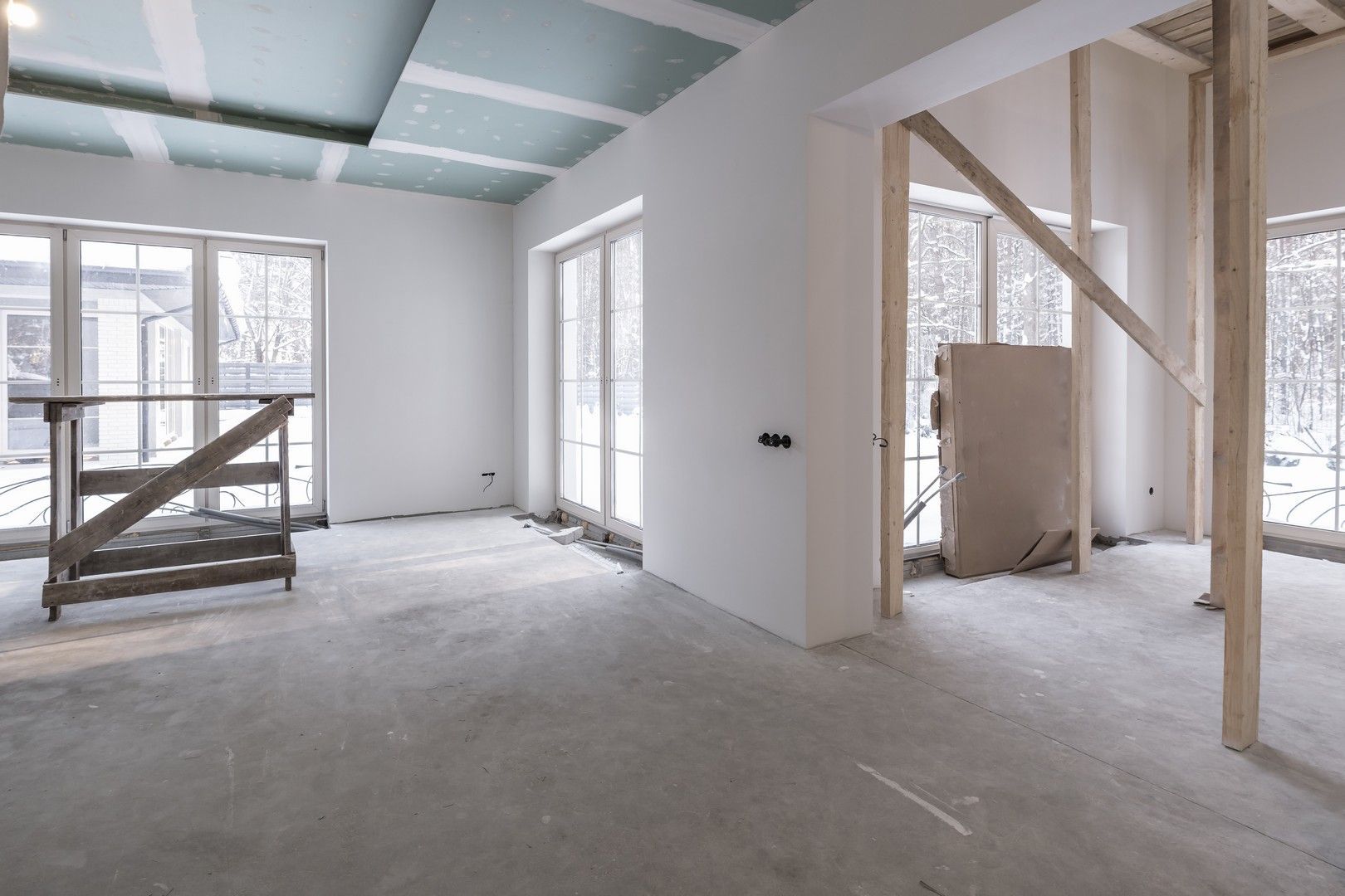 Una stanza vuota con molte finestre in una casa in costruzione.