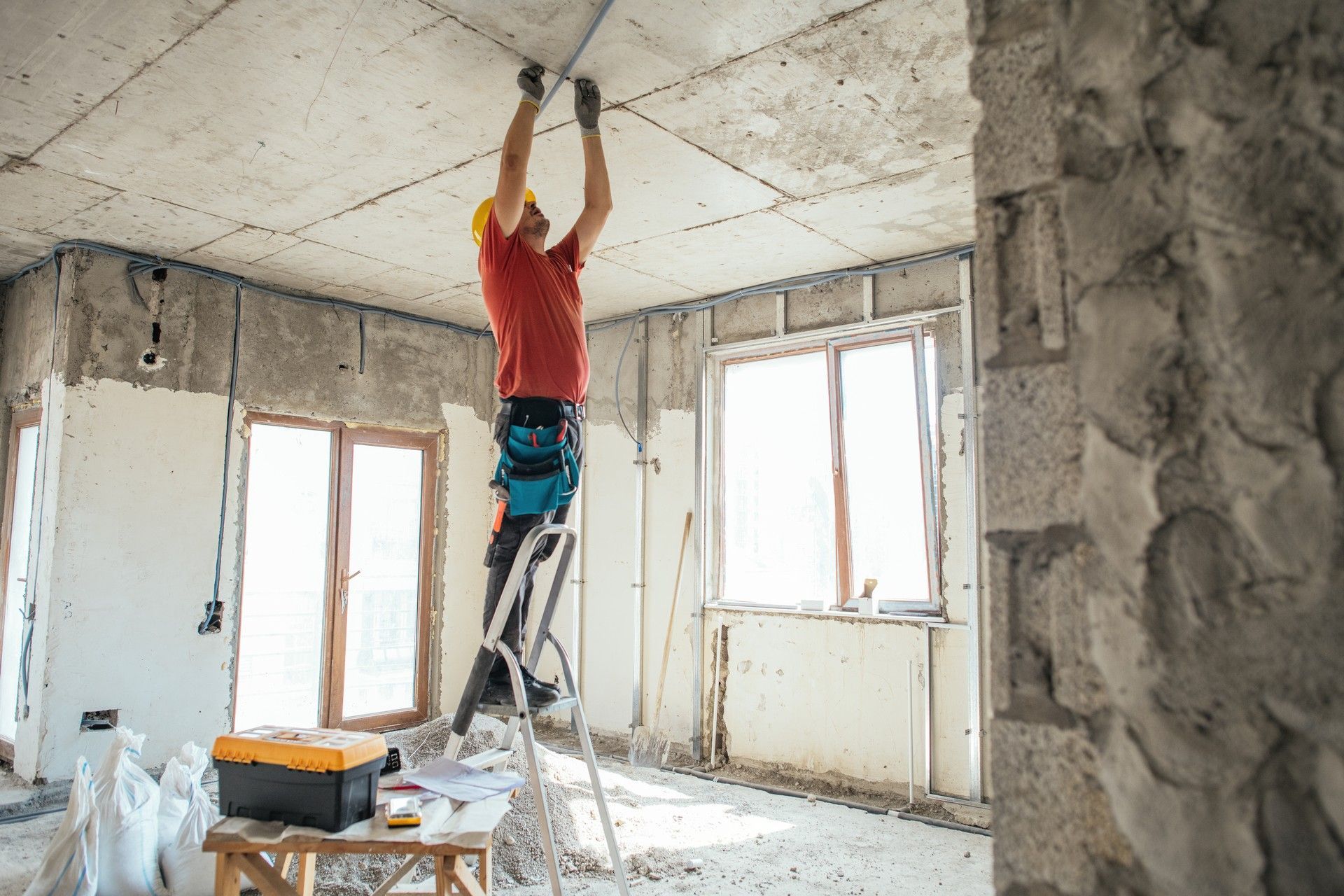 Un uomo è appeso al soffitto mentre si trova su una scala.