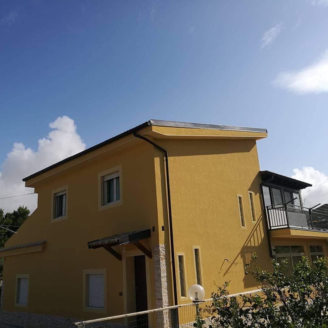 Una casa gialla con un cielo azzurro sullo sfondo