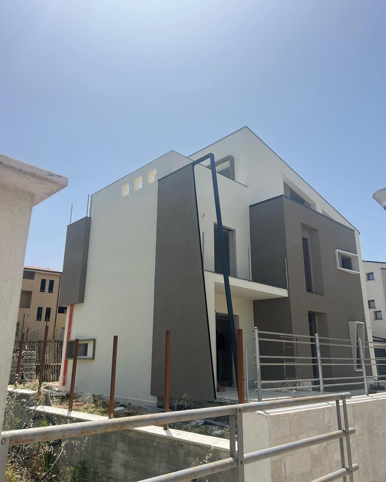 Una grande casa con un recinto attorno e un cielo azzurro sullo sfondo