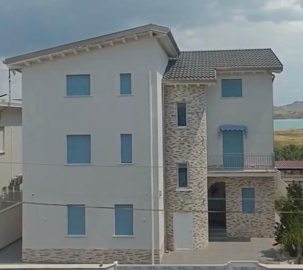 Un grande edificio bianco con finestre e porte blu