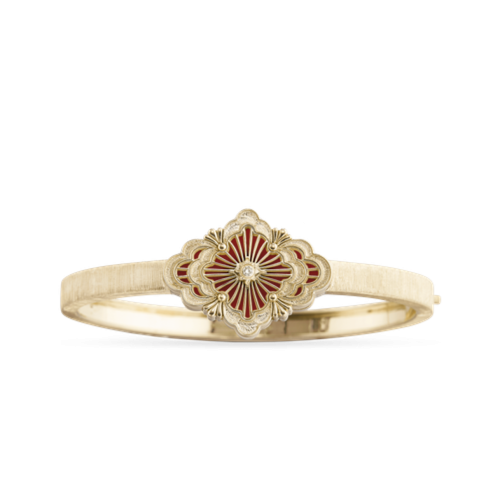 Un anello d'oro con un fiore rosso su sfondo bianco.