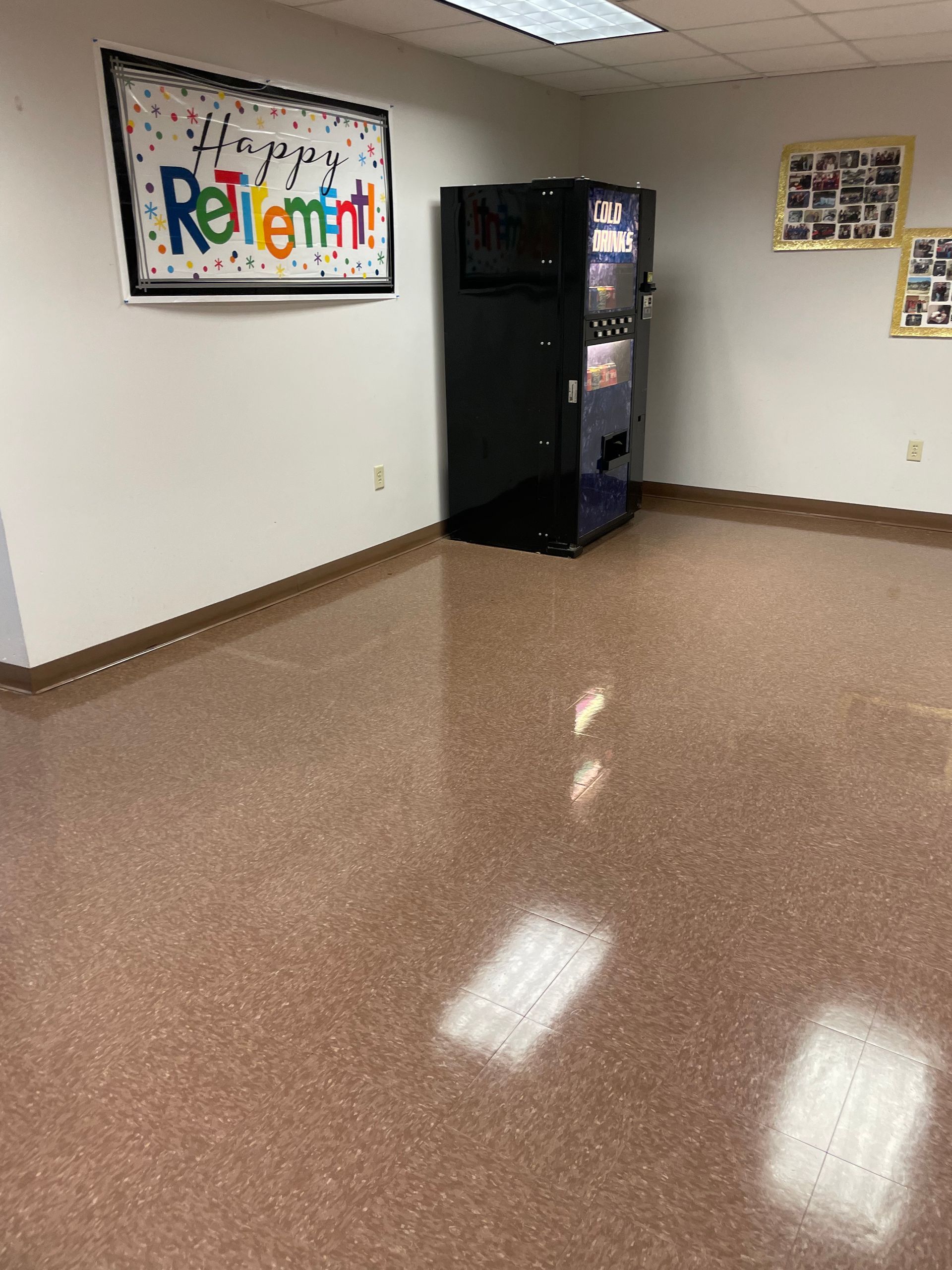 A room with a vending machine and a sign on the wall that says `` happy retirement ''.