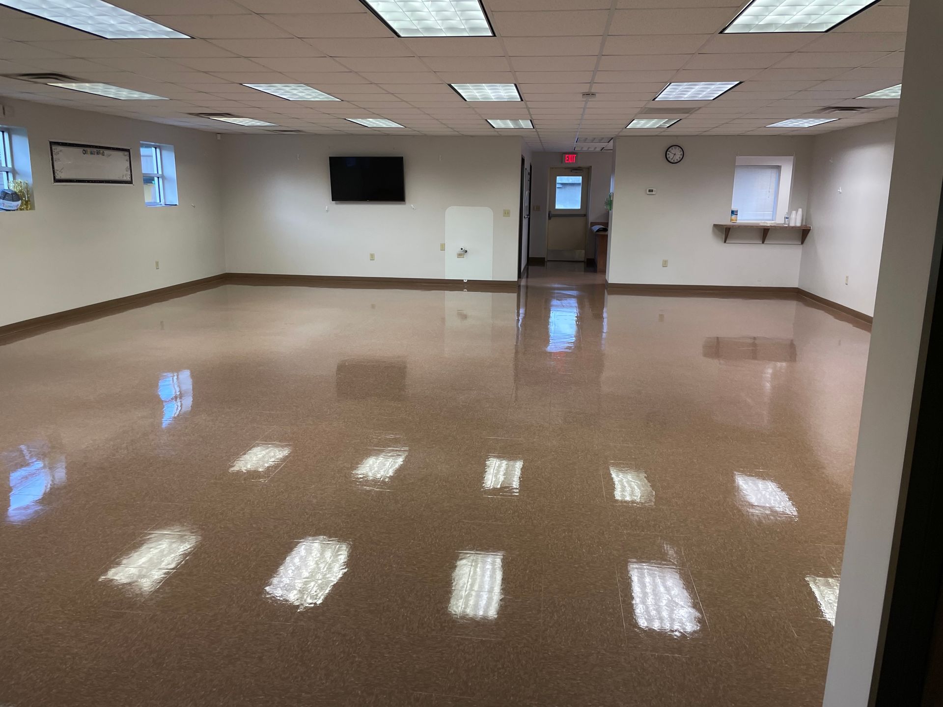 A large room with a brown floor and white walls