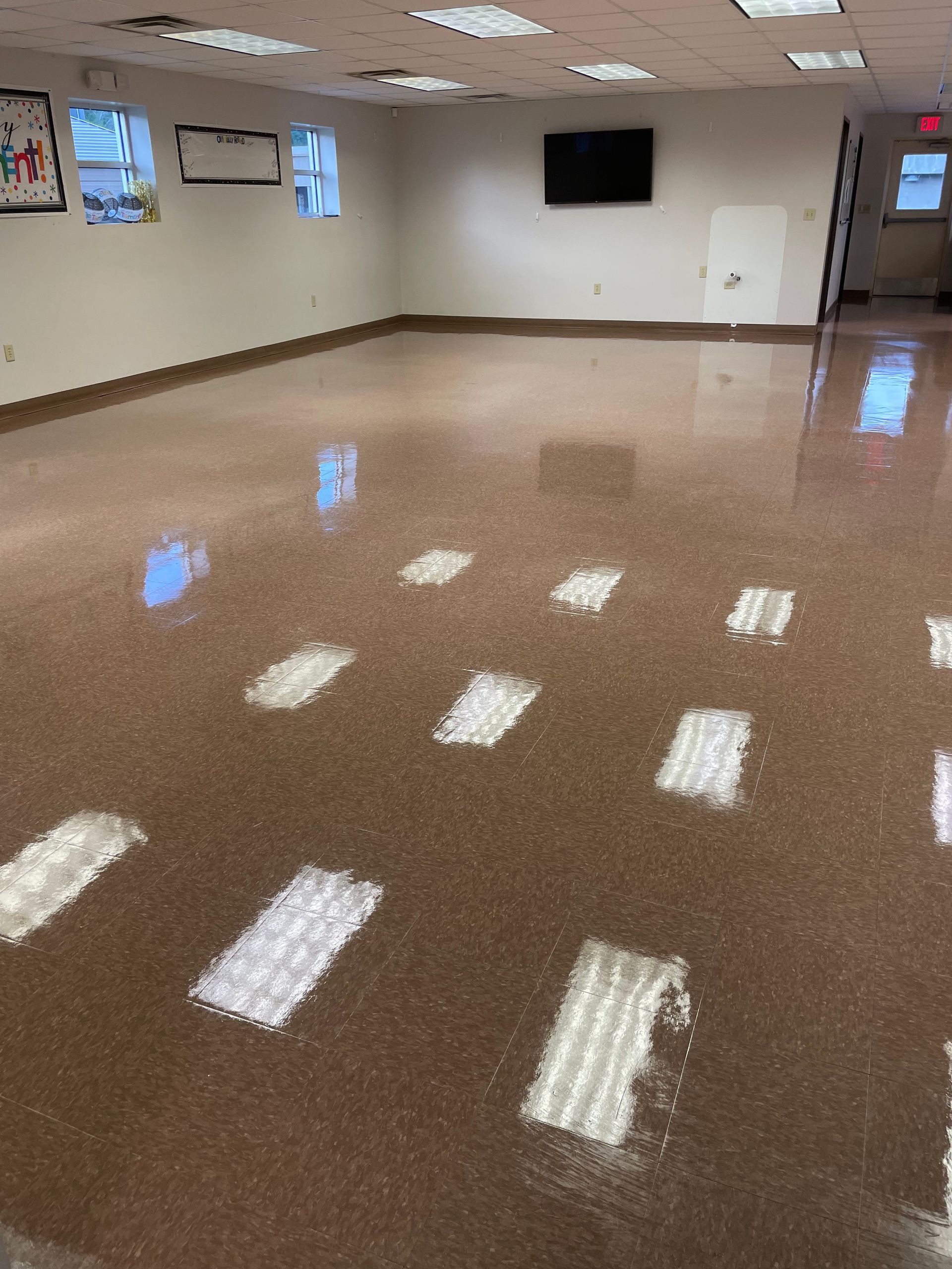 A large room with a shiny floor and a lot of windows