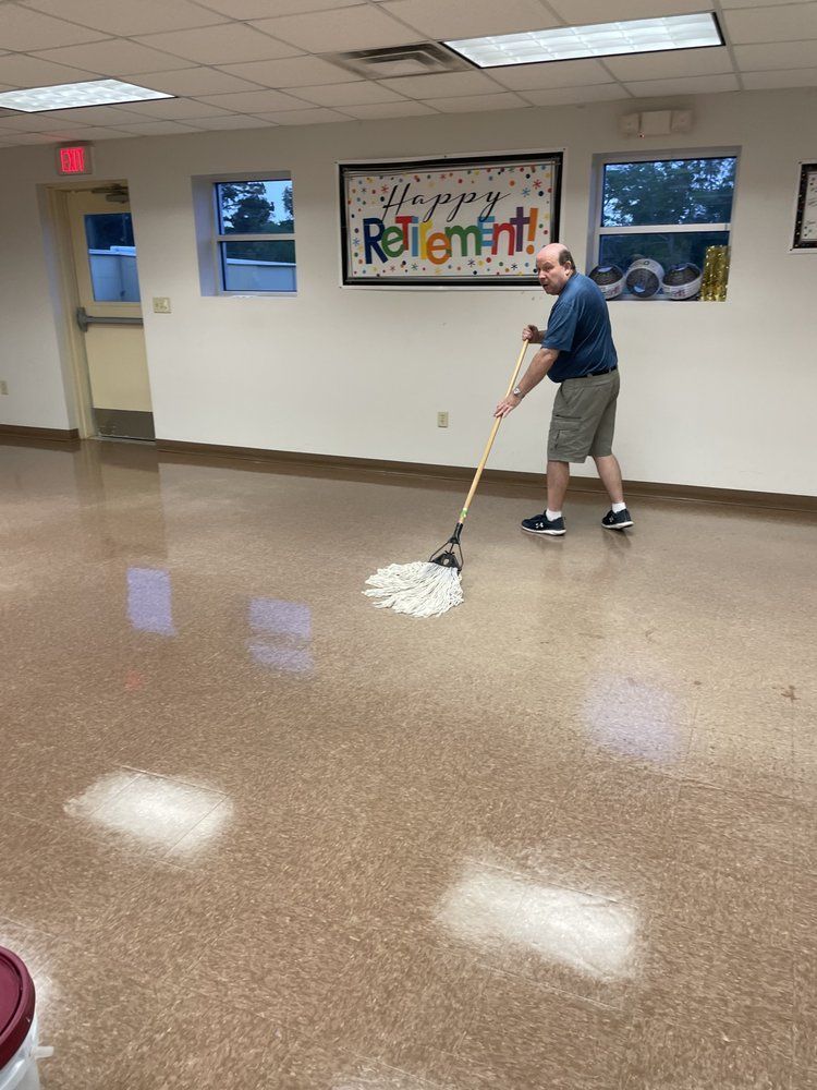A man is mopping the floor of a room in front of a sign that says retirement.