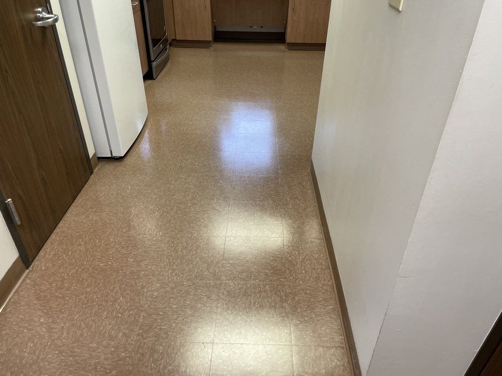 A hallway leading to a kitchen with a shiny tile floor.