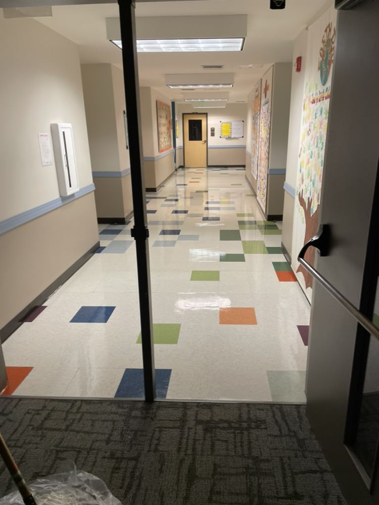 A hallway with colorful tiles and a door that is open