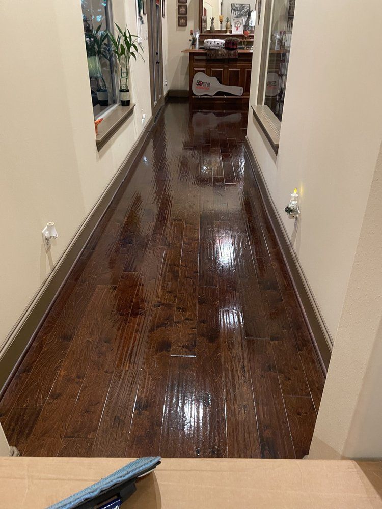 A long hallway with hardwood floors and a key on the wall.