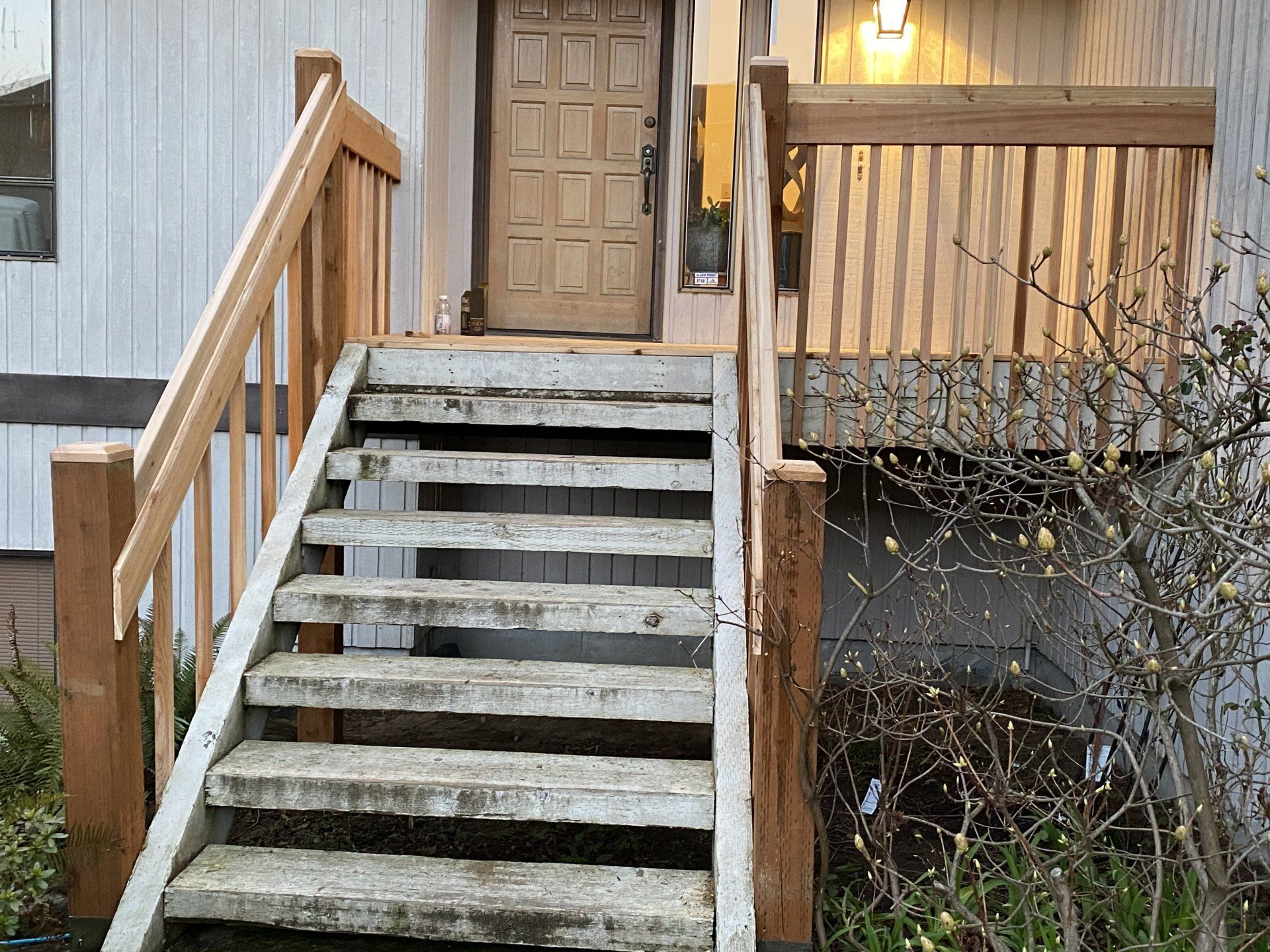Wooden stairs leading up to a porch with a front door.