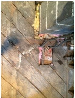 Wood paneling with insulation and wiring visible; damaged area.