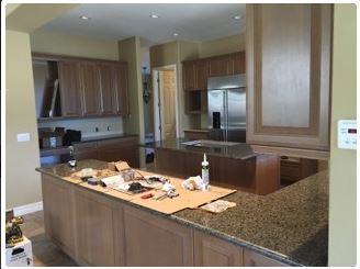 Kitchen with brown cabinets, granite countertops, and stainless steel refrigerator.