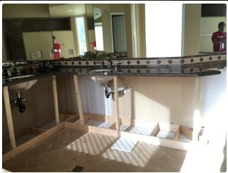 Kitchen remodel: partially built cabinets with granite countertop and sink.