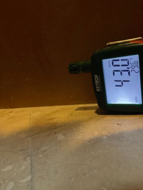 Black digital meter on a stone surface displays 