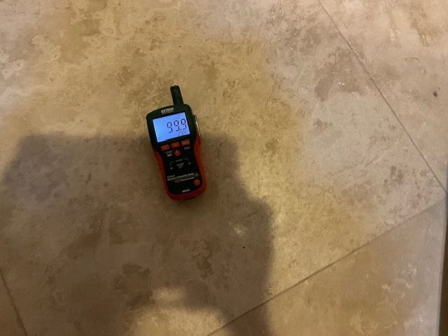 A red and black meter displaying 0.00 on a light brown tiled floor.