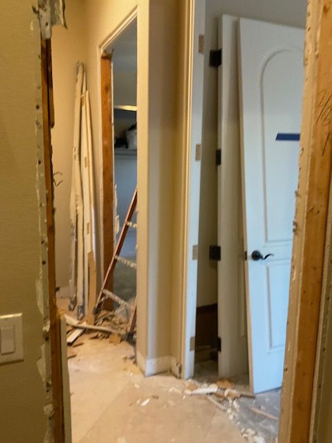 Hallway under renovation with door frames and debris.