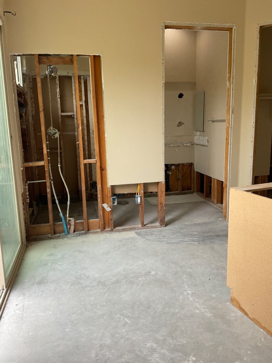 Bathroom in renovation: exposed studs, shower plumbing, and partially demolished walls.