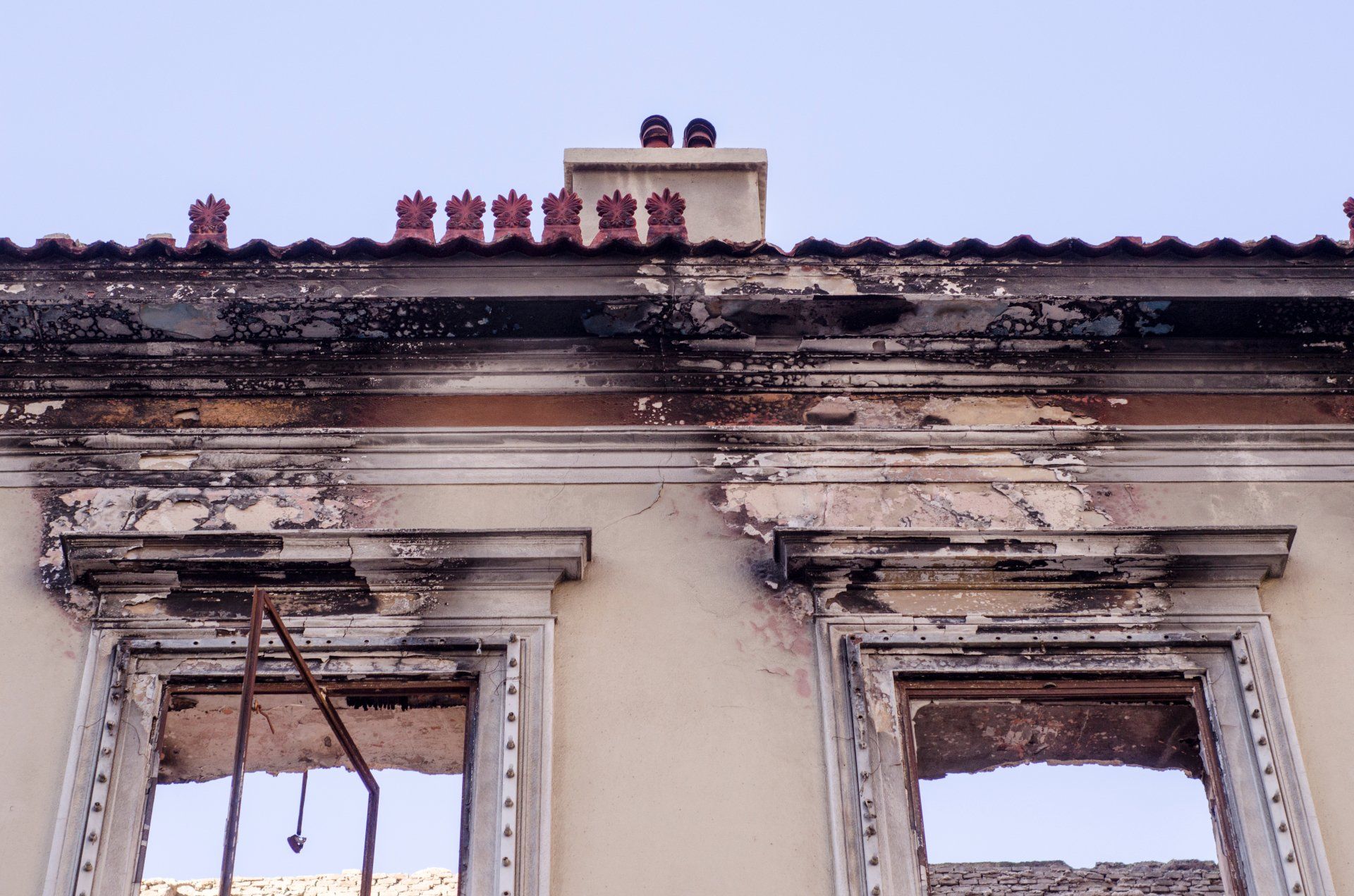 Building facade with burnt window frames and black soot damage.