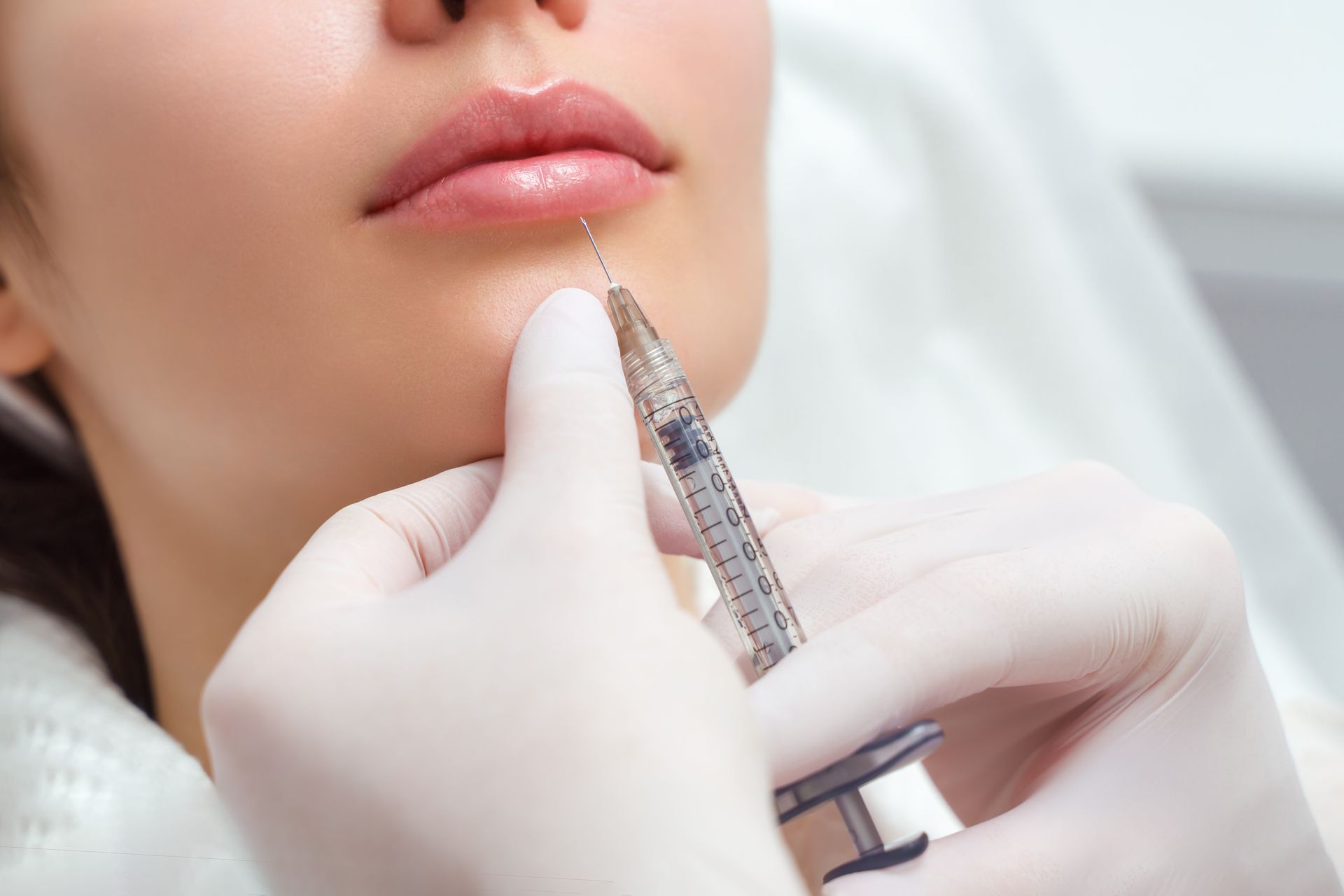 A woman is getting a botox injection in her face.