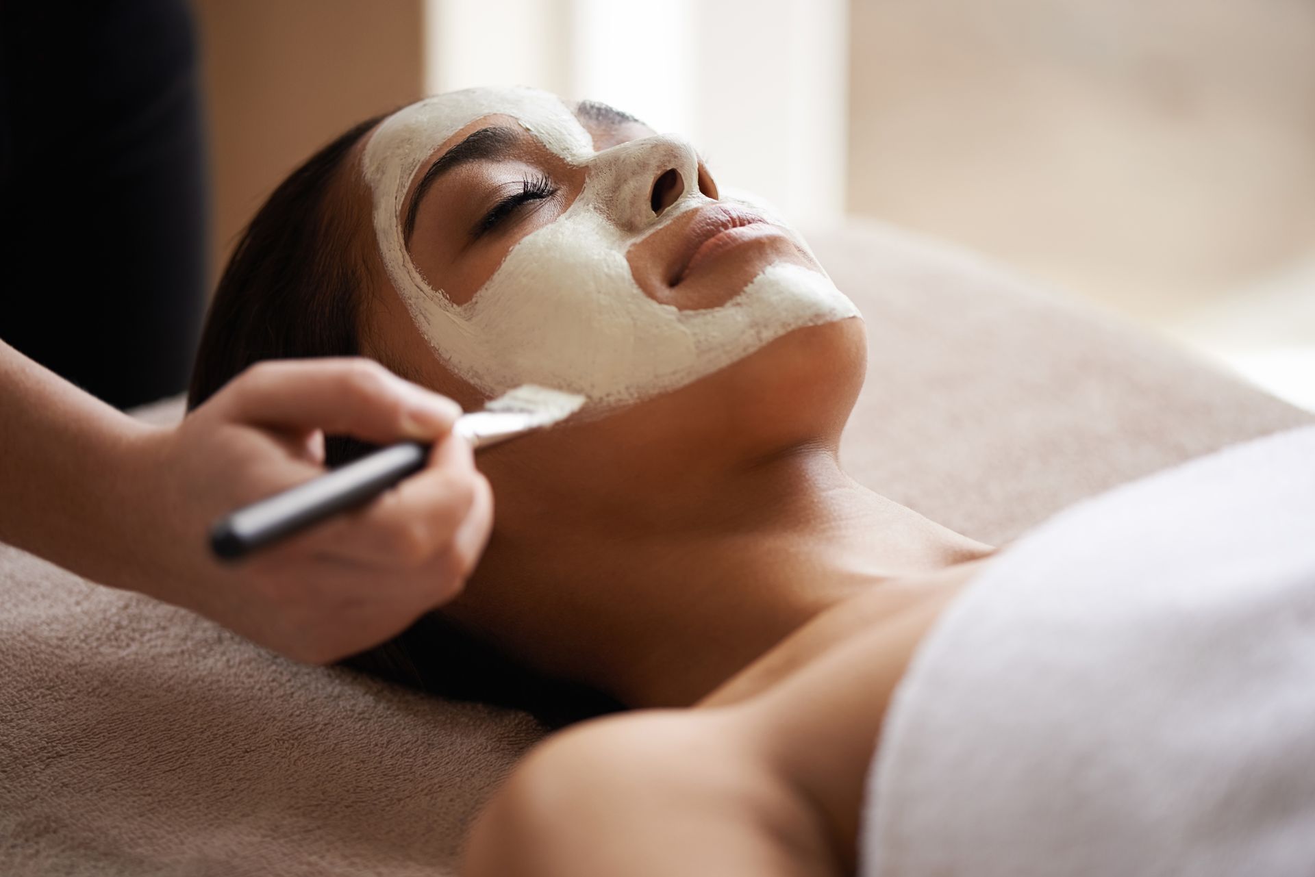 A woman is getting a facial treatment at a spa.