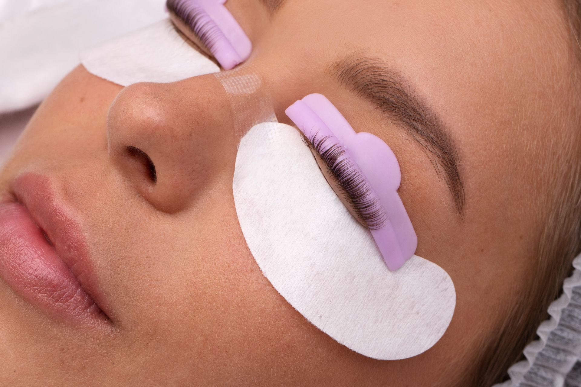 A woman is getting her eyelashes done at a beauty salon.
